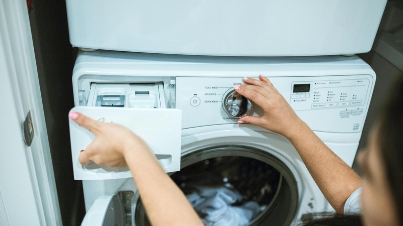 洗濯機の設定と洗剤投入口を見ながら使い方を確認するイメージ