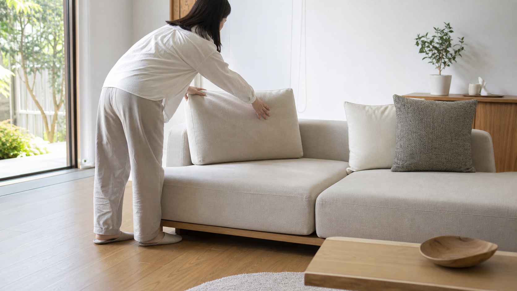 背もたれの低いアイランドソファでクッションの使い方を確認する様子