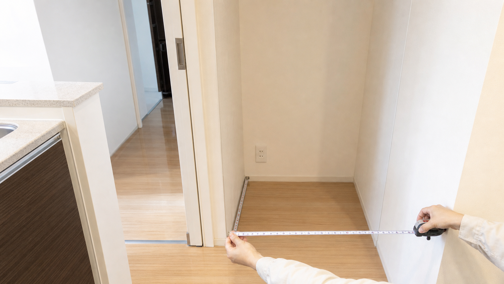冷蔵庫置き場の幅と奥行きをメジャーで測る様子